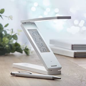 Gadget with logo Desktop lamp weather station ZETA Gadget with logo 18 LED foldable desktop lamp in ABS with Desktop lamp weather station. Displays time,temperature. Alarm function. 1 CR2032 battery included. Depending on the surface we can use embroidery, engraving, 360° imprint or screen print.