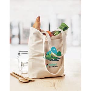Gadget with logo Totebag RASSA Canvas shopping bag with logo with long handles and with bottom gusset. An ideal bag for your daily grocery shopping. The long handles make it easy to carry it by either holding it or hanging it over your shoulder. This canvas tote has a base gusset so you can carry more items than with a regular shaped bag. 270 gr/m². Produced under a certified standard for the use of harmful substances in textile. Available color: Beige Dimensions: 38X9X42 CM Width: 9 cm Length: 38 cm Height: 42 cm Volume: 0.722 cdm3 Gross Weight: 0.164 kg Net Weight: 0.149 kg Magnus Business Gifts is your partner for merchandising, gadgets or unique business gifts since 1967. Certified with Ecovadis gold!