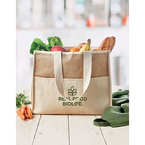 Gadget with logo Totebag CAMPO DE GELI Jute shopping and cooler bag with logo with long handles, laminated and with hookand loop closure, front with canvas pocket and cotton webbing. Available color: Beige Dimensions: 43X20X34CM Width: 20 cm Length: 43 cm Height: 34 cm Volume: 2.229 cdm3 Gross Weight: 0.364 kg Net Weight: 0.292 kg Magnus Business Gifts is your partner for merchandising, gadgets or unique business gifts since 1967. Certified with Ecovadis gold!