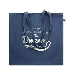 Gadget with logo Totebag STYLE TOTE 50% Recycled cotton dye denim and 50% cotton shopping bag with logo with long handles. 250 gr/m². This tote is perfect for daily grocery shopping or carrying other items with you. Carry the bag with your hands or hang it over your shoulder to keep your hands free. The denim look makes this stylish bag stand out. Available color: Blue Dimensions: 42X40CM Width: 40 cm Length: 42 cm Volume: 0.6 cdm3 Gross Weight: 0.15 kg Net Weight: 0.137 kg Magnus Business Gifts is your partner for merchandising, gadgets or unique business gifts since 1967. Certified with Ecovadis gold!