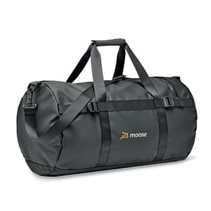 Bag with logo Jaya Duffle Duffle bag, sports or travel bag in 50C tarpaulin with zippered side compartment and zippered inner pocket. With comfort grip handle and padded base. Dimensions: 49X28X28CMWidth: 28 cm Length: 49 cm Height: 28 cm Volume: 7.5 cdm3Gross Weight: 0.75 kg Net Weight: 0.65 kg Available colour black. Magnus Business Gifts is your partner for merchandising, gadgets or unique business gifts since 1967. Certified with Ecovadis gold!